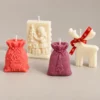 scentulp-kerstverhaal-cadeauset-03-detail Kerstverhaal Cadeauset van Scentulp: koraalroze rendierzak, paarse kerstboomzak, ivoorkleurig kersttafereel en rendier met rode strik als kaarsen — detail van de handgemaakte kaarsen.